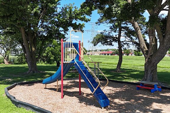 A playground with a blue slide and a red and yellow structure.