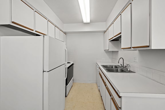 A kitchen with white cabinets and appliances.