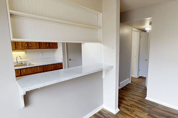 A white kitchen with a sink and a window.