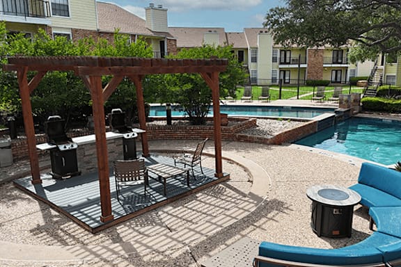 A poolside area with a table and chairs.