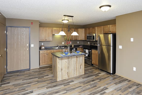 A kitchen with a wooden island and stainless steel appliances.