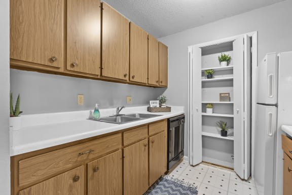 a kitchen with wooden cabinets and a black dishwasher