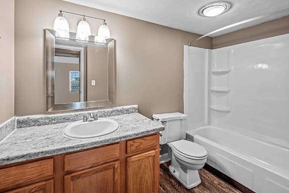 A bathroom with a marble countertop and a white toilet.