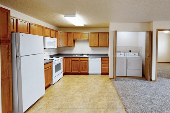 A kitchen with wooden cabinets and white appliances.