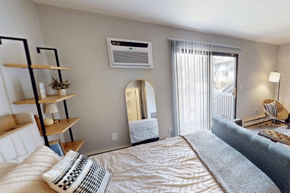 A bedroom with a large bed and a mirror on the wall.