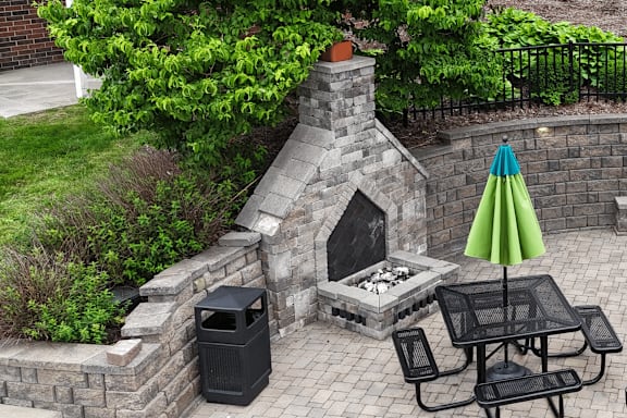 A patio with a table, chairs, and an umbrella.