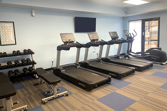 a gym with cardio equipment and weights in a building