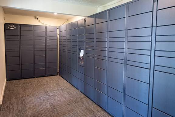 A hallway with a carpeted floor an amazon hub for package delivery