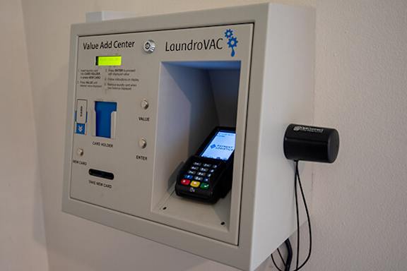 A laundromat Value Add Center with a phone for payment.