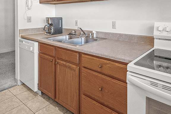 A kitchen with a white oven and wooden cabinets.