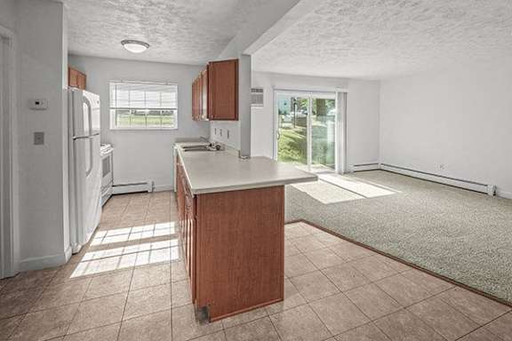 A kitchen with white appliances and brown cabinets.