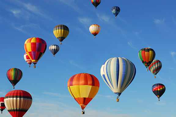 A group of colorful hot air balloons floating in the sky.