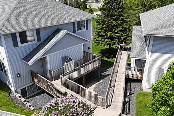 A house with a grey roof and a deck with stairs.
