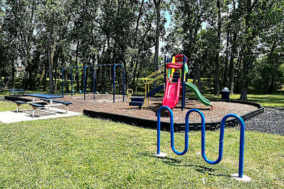 A playground with a slide, swings, and a picnic table.