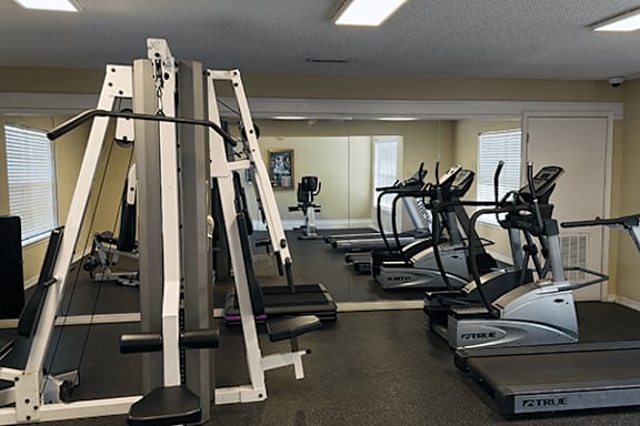 A gym with treadmills, weight machines, and exercise equipment.