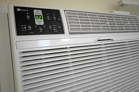 A white air conditioner with a digital display and several buttons.