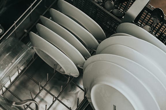 Plates are stacked in a dishwasher.