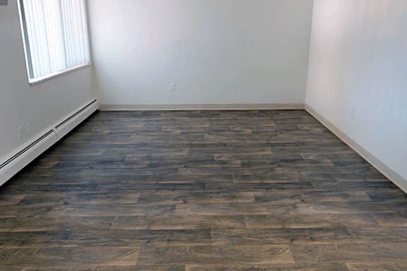 A room with a wooden floor and a window.