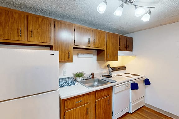 A kitchen with wooden cabinets and white appliances.