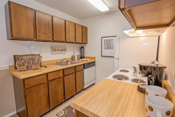 a kitchen with wooden cabinets and a white stove top oven