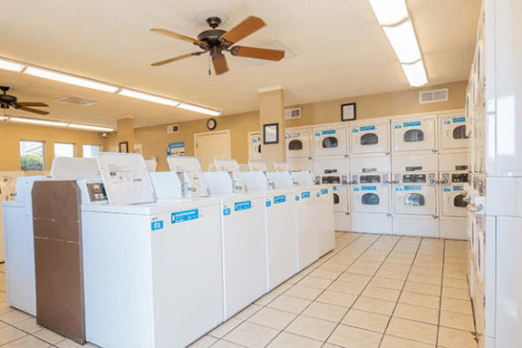 a large laundry room with washers and dryers