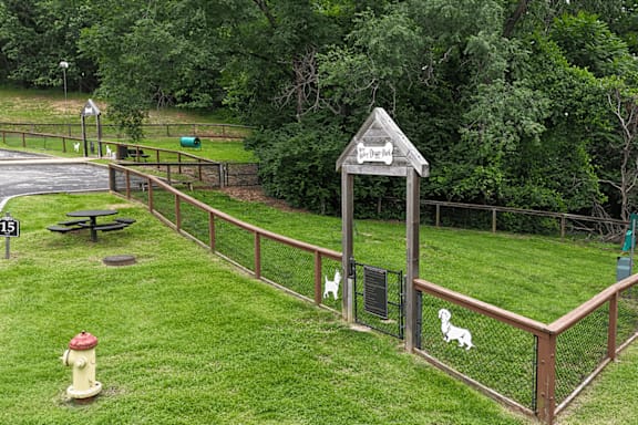 A dog park with a sign that says "Dog Park" and a fire hydrant.