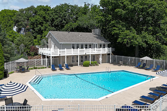 A pool with a house in the background.