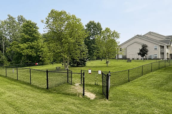A green field with a fence and a sign.