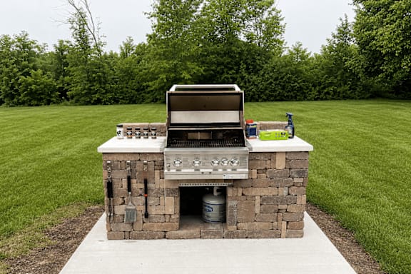 A stone built BBQ with a grill on top.