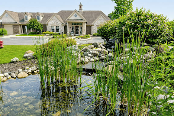 A house with a pond in front of it.