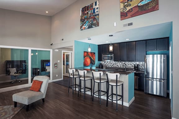a kitchen and living room with a bar and stools