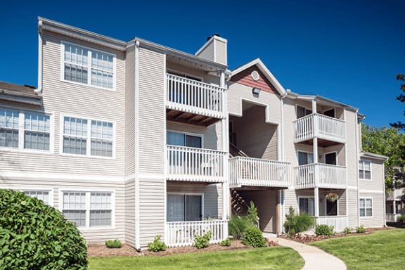 a building with white siding and a sidewalk
