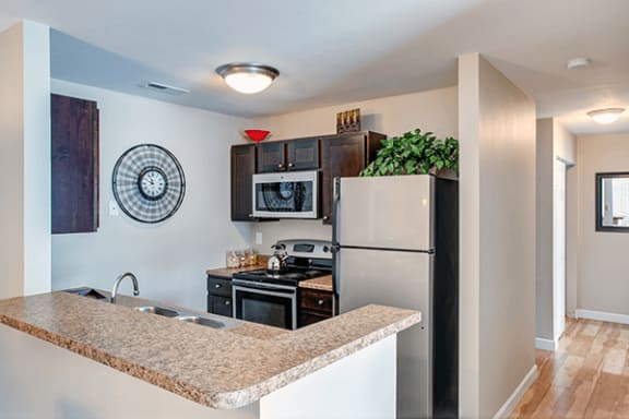 a kitchen with a granite counter top and a stainless steel refrigerator