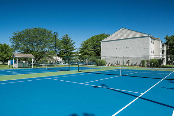 two tennis courts with a building in the background