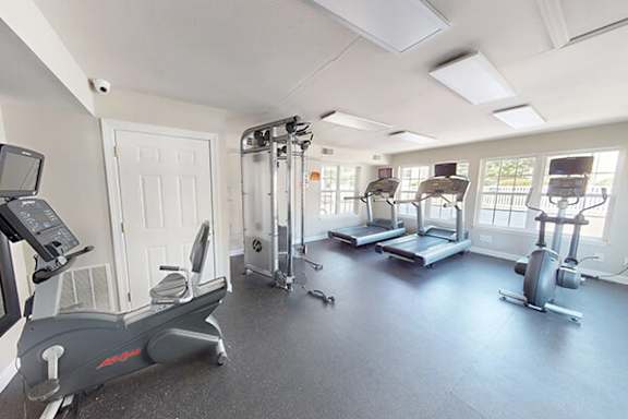 A gym with treadmills, elliptical machines, and other exercise equipment.