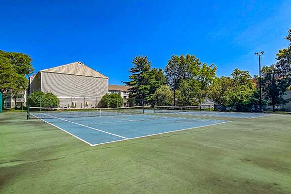 A tennis court with a blue surface and white boundary lines.