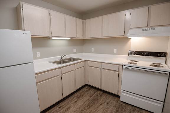 A kitchen with white appliances and wooden cabinets.