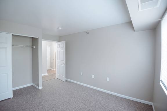 A large empty room with a doorway leading to another room.