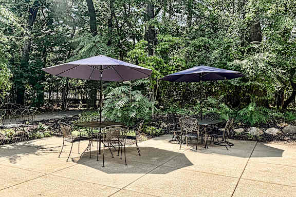 A patio with a table and chairs under umbrellas.