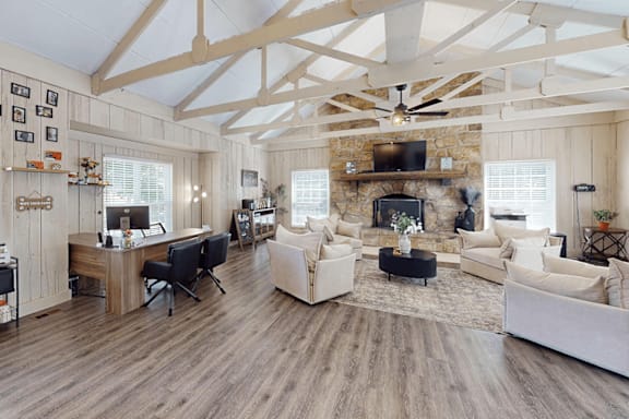 A spacious living room with a fireplace and a ceiling fan.