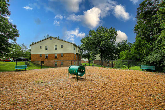 a fenced in dog park with a house in the background