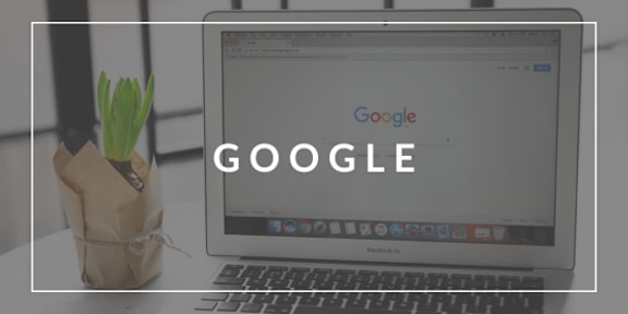 A MacBook Air is open and the screen displays the Google logo.