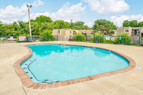 a resort style pool with trees and buildings in the background