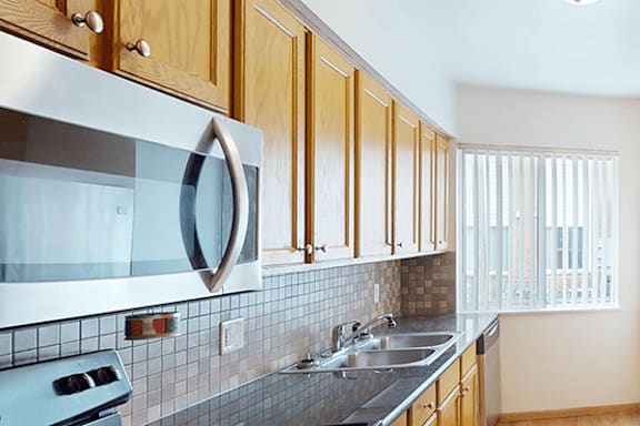 A kitchen with wooden cabinets and a stove top oven.