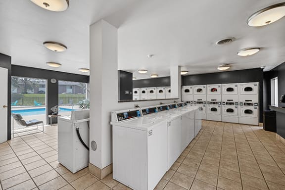 community laundry room with washers and dryers and a pool in the background
