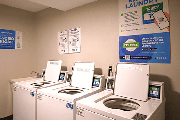 A row of washing machines in a laundromat.