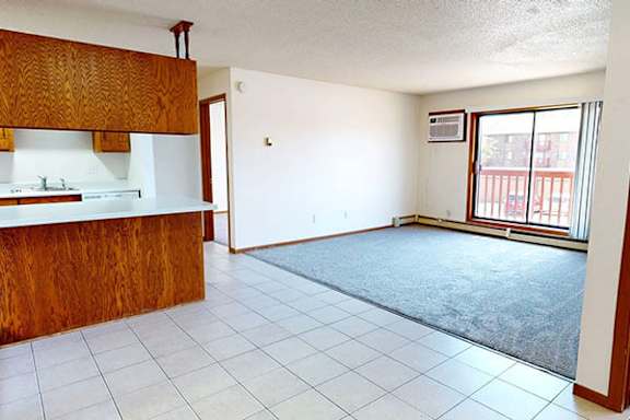 A kitchen with white tiles and a wooden counter.