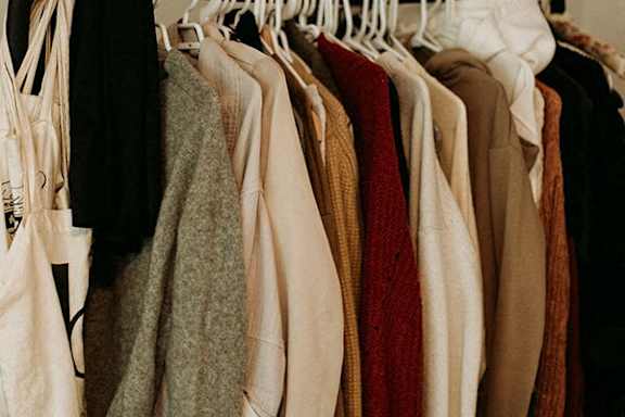 A row of clothes hanging on a rack.