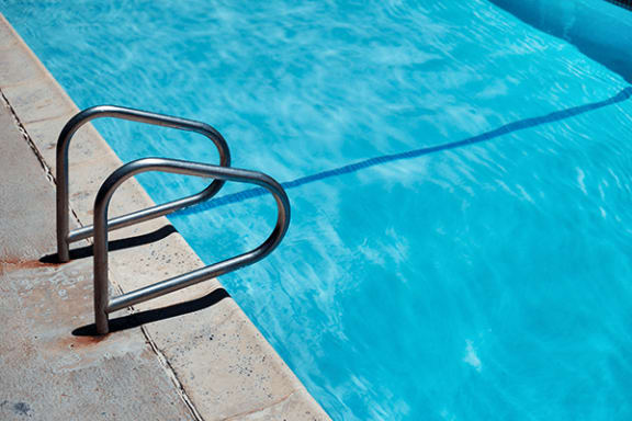 a swimming pool with a metal ladder on the side of it