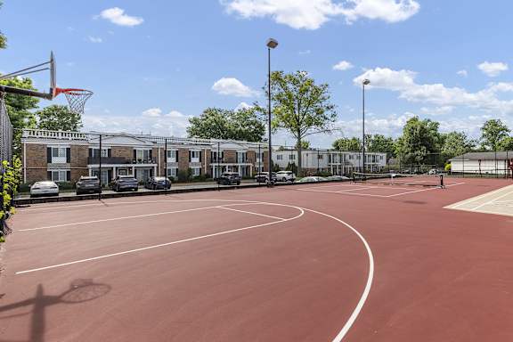 A basketball court with a basketball hoop and a basketball on the ground.